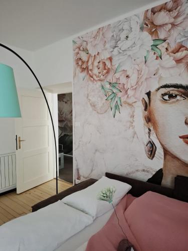 una camera da letto con un murale di una donna di Apartment wildflower in Privatvilla im Herzen Merans a Merano