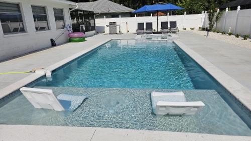 a swimming pool with two lounge chairs in it at Luxury 3BD house, Siesta Key Beach in Sarasota