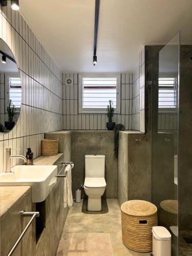 a bathroom with a white toilet and a sink at The Paarl Grand in Paarl