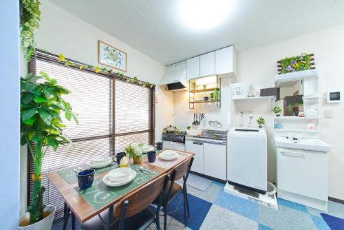 a kitchen with a wooden table and a kitchen with white appliances at Belmont 201 3min to Station Easy Access Ueno Asakusa Skytree Sleeps 5 in Tokyo