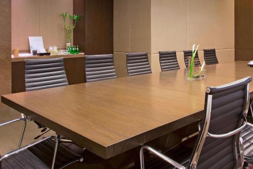 a conference room with a large wooden table and chairs at The Westin Mumbai Garden City in Mumbai