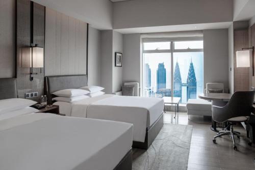 a hotel room with two beds and a desk at Chongqing Marriott Hotel in Chongqing