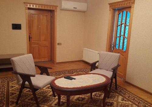 a room with two chairs and a table and a door at Ali Baba Residence in Gabala