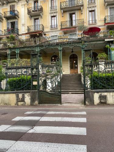 une entrée d'un bâtiment avec un portail ouvert dans l'établissement Studio AIX LES BAINS, à Aix-les-Bains