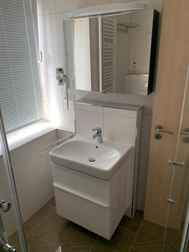 a white bathroom with a sink and a mirror at Idylle in Thale