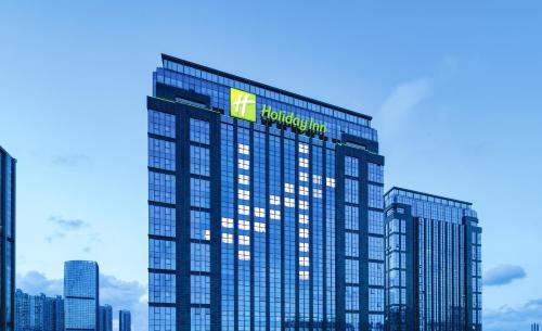 a tall building with a sign on top of it at Holiday Inn Shenzhen Nanshan by IHG in Shenzhen