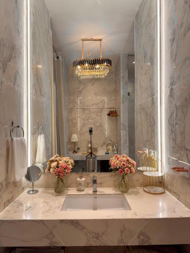 a bathroom with a sink and a chandelier at The Atlantic Langkawi in Pantai Cenang