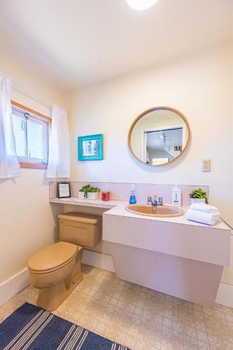 a bathroom with a sink and a toilet and a mirror at Peabody House - 1920s Cottage in Port Angeles