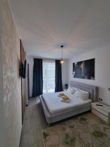 een slaapkamer met een bed en een groot raam bij Apartament SIMINA ALZ -2 camere in Mamaia Nord – Năvodari