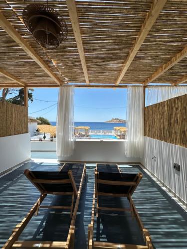 two chairs on a porch with a view of the ocean at SPONGIA HOTEL SUITES & Spa in Myrties