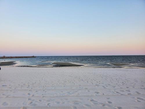 a beach with footprints in the sand and the ocean at Courtyard by Marriott Gulfport Beachfront in Gulfport