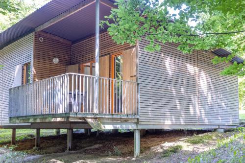 a wooden house with a deck on the side of it at Les Charmes C18 - Le Val Joly in Eppe-Sauvage