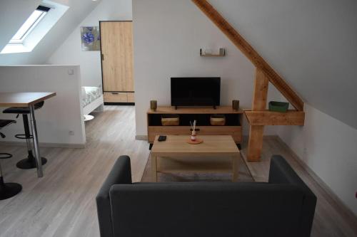 a living room with a couch and a table at Bords de l'Aure, Meublé de tourisme 3 étoiles in Bayeux