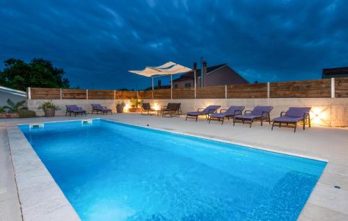 een zwembad met ligstoelen en een parasol bij Villa Baraka in Rovinj