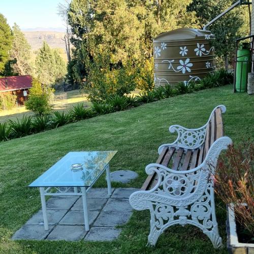 a bench next to a table and a trash can at The Fat Mulberry Guest Farm in Fouriesburg