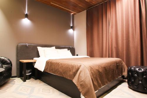 a bedroom with a bed and a chair at Hotel Avant in Cheonan