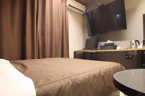 a hotel room with a bed and a flat screen tv at Hotel Avant in Cheonan