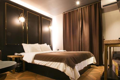 a hotel room with a bed and a window at Hotel Avant in Cheonan