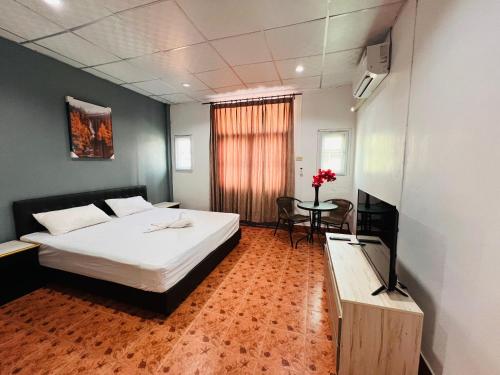 a hotel room with a bed and a table with a television at Patong Adventure Hostel in Patong Beach