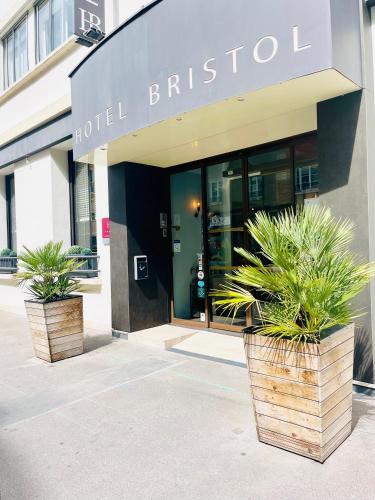 two potted plants in front of a hotel building at L'Hôtel Bristol in Caen