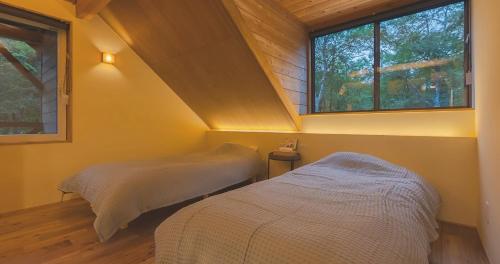 MureにあるSanso Yukitsubakiの窓のある小さな部屋にベッドが2つある