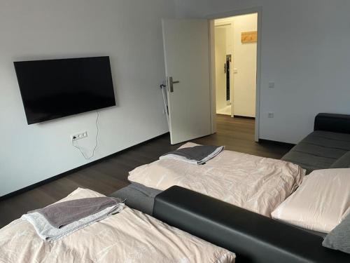 a room with two beds and a flat screen tv at 1 Zimmer Ferienwohnung in Essen in Essen