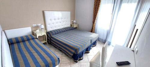 a bedroom with two beds in a room at Hotel Viña del Mar Pineta in Lido di Jesolo