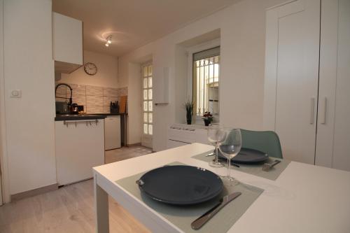 une cuisine avec une table avec des assiettes et des verres à vin dans l'établissement Le Nid de la Colombe - Hypercentre, à Toulouse