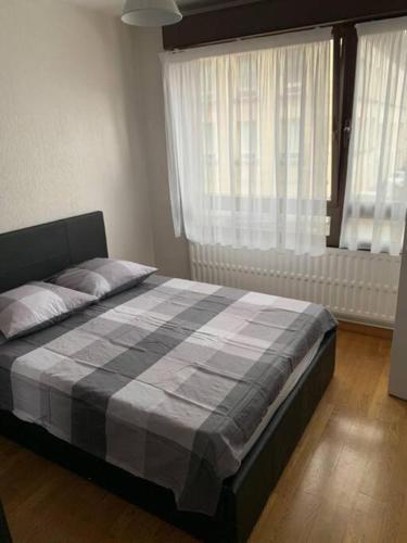 - une chambre avec un lit et une couverture en damier dans l'établissement Reims centre-ville -au1er étage avec 2 chambres - 6 personnes, à Reims
