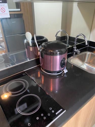 a pot and pans sitting on a stove in a kitchen at Good and Homey 1BR Apartment at Mustika Golf Residence By Travelio in Cikarang