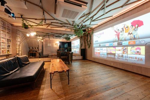 a room with a couch and a table and a large screen at Grand Piano & Shinjuku 5min walk from station in Tokyo