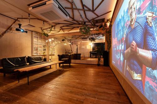 a room with a large screen with a couch and a table at Grand Piano & Shinjuku 5min walk from station in Tokyo