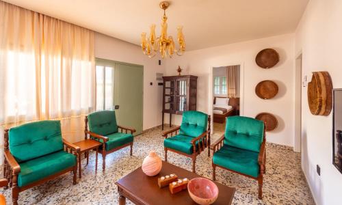 a living room with green chairs and a table at Diamante Guest House-Ground in Mağusa