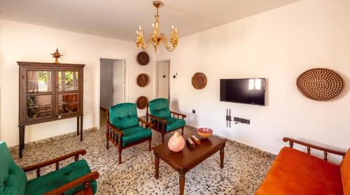 a living room with green chairs and a table at Diamante Guest House-Ground in Mağusa