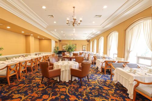 a dining room with tables and chairs and a chandelier at La Vie Dor Hotel and Resort, Trademark Collection by Wyndham in Hwaseong