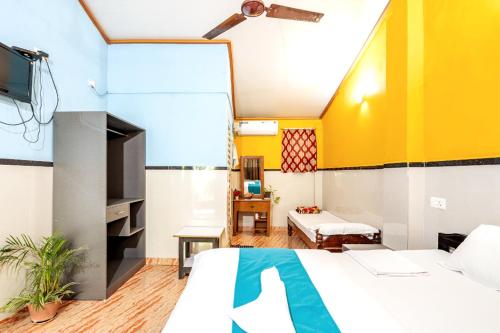 a hotel room with a bed and a tv at Casanova by the Sea - Just a walk away to Canacona Beach in Palolem