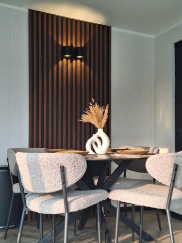 a dining room with a table and chairs at 'Relax Lodge Sea' - Wellness lodge in Zeeland - Private Sauna - Airco - Garden - Outdoor Swimming pool - Free Wifi, Towels & Bed linen in Heinkensand