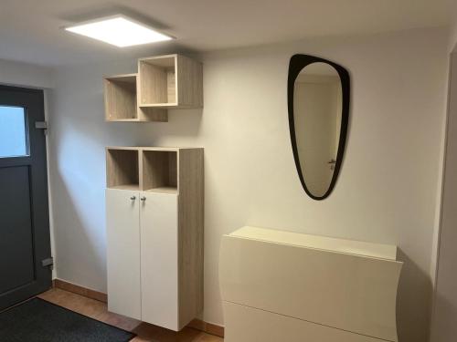 a bathroom with a mirror and a white cabinet at Ferienwohnung Bauer in Puschendorf