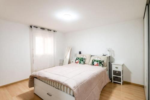 una camera da letto bianca con un letto e una finestra di L'Escapade du Lac - Proche du Lac Léman a Évian-les-Bains