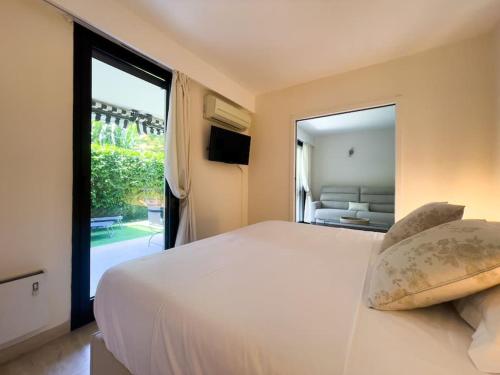 une chambre avec un grand lit et une grande fenêtre dans l'établissement Rénové, grande terrasse, piscine, au calme absolu, à Cannes