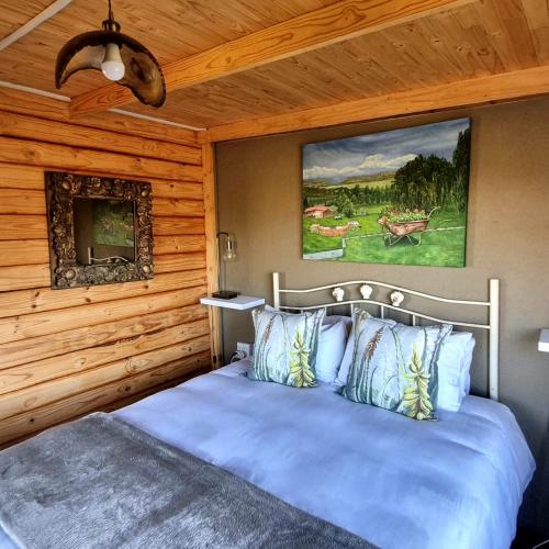 a bedroom with a blue bed in a cabin at The Fat Mulberry Guest Farm in Fouriesburg