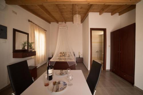a dining room with a table and a bed at Bodikos Apartments in Pitsidia