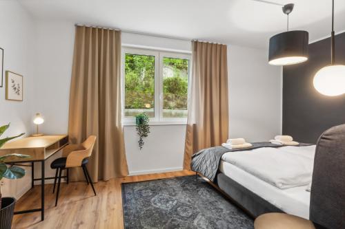 a bedroom with a bed and a desk and a window at Stylisches Apartment mit Terrasse & kostenlosem Parkplatz Beste Lage in Bielefeld in Bielefeld