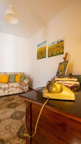 a living room with a table and a couch at Dimora del Pittore, Usellus in Usellus