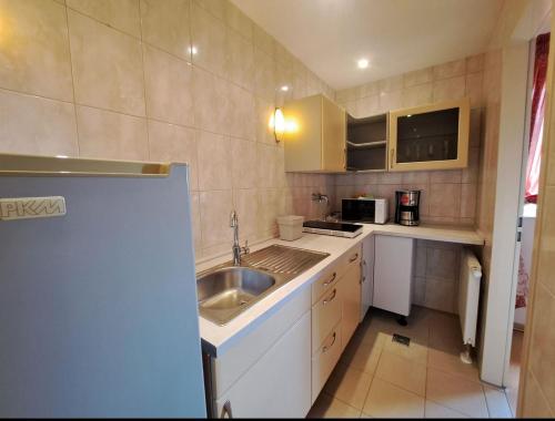 a small kitchen with a sink and a microwave at Mediterran Hotel Juwel in Karlstein am Main