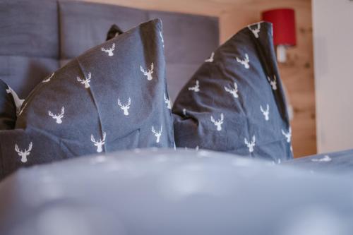 a bed with black pillows with white bugs on them at Alpenzeit in Ladis
