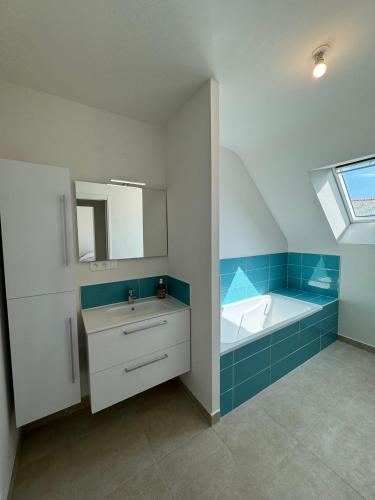 une salle de bain avec un lavabo et une baignoire dans l'établissement Maison au calme, proche plage, wifi, jardin clos, à Quiberon