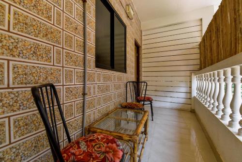 two chairs and a table in a room with tiles at Rosa Bella Resort-TBV in Calangute