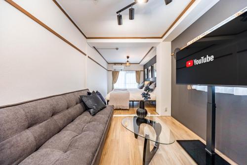 a living room with a couch and a flat screen tv at アリタマンション日本橋 in Osaka