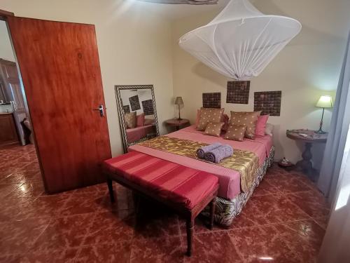 a bedroom with a bed with a bench and a mirror at Apartment 3bedrooms 2bathrooms rooftop jacuzzi in Pointe aux Sable